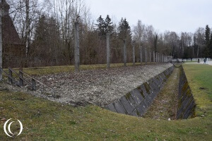 Moat and electrical fence on the inside of the fence in Dachau