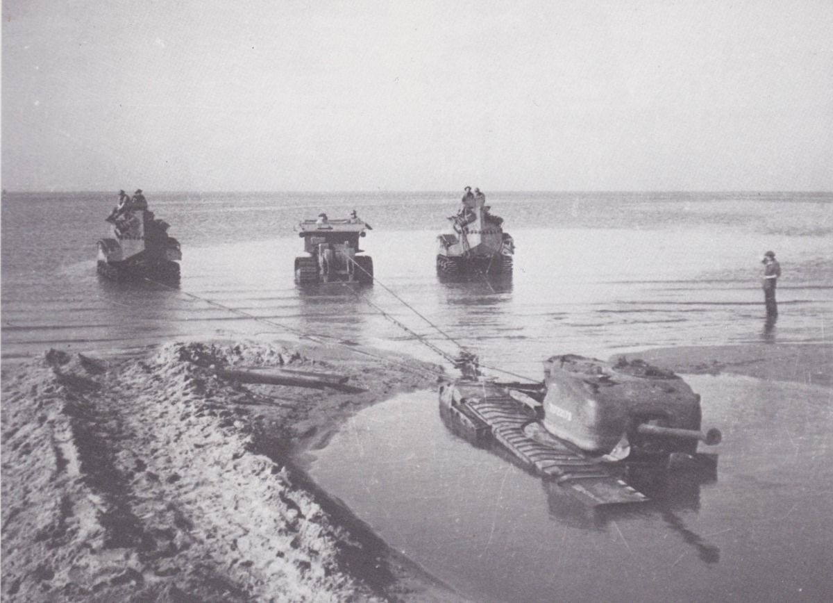 Two Sherman BARVs and one D8 BARV recover a stranded Churchill tank - Photo HMSO, Vanguard of Victory The 79th Armoured Division